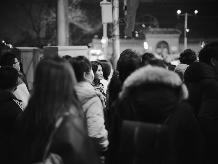 一张黑白照片 描绘了夜晚火车站的人群