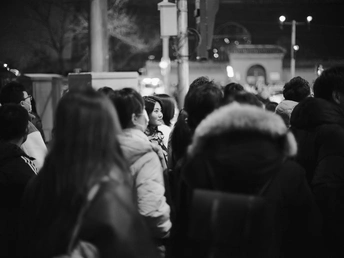 一张黑白照片 描绘了夜晚火车站的人群