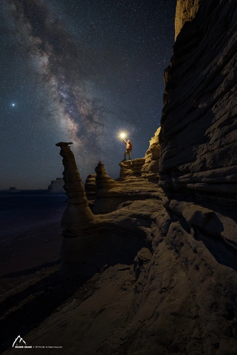 站在海滩上的男人在夜晚仰望星空