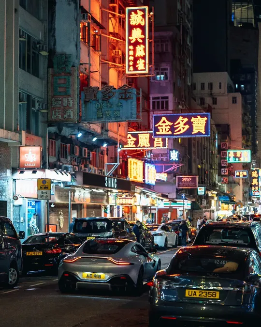 夜晚充满汽车、建筑和亮起的招牌的城市街道