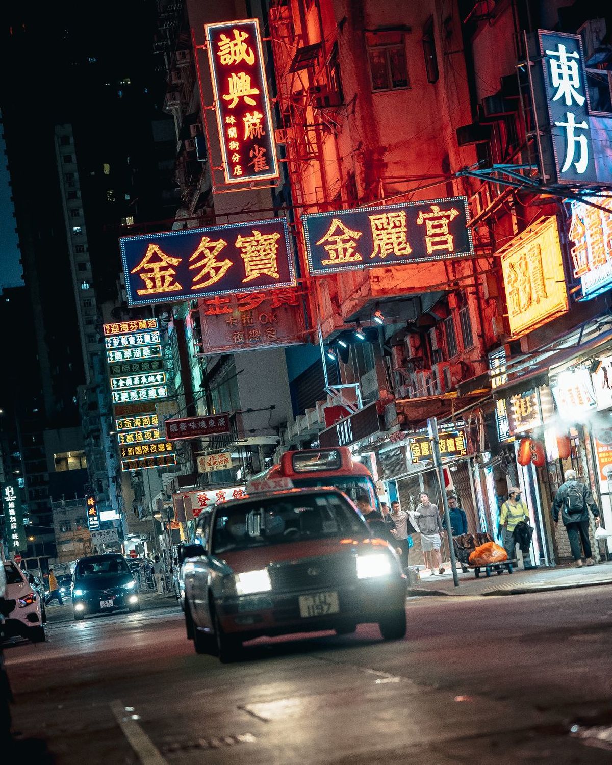 夜晚的城市街道 汽车沿着街道行驶 建筑物上的霓虹灯