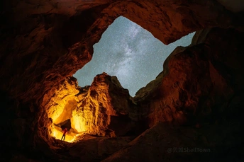 夜晚洞穴中的男子与天空中的星星