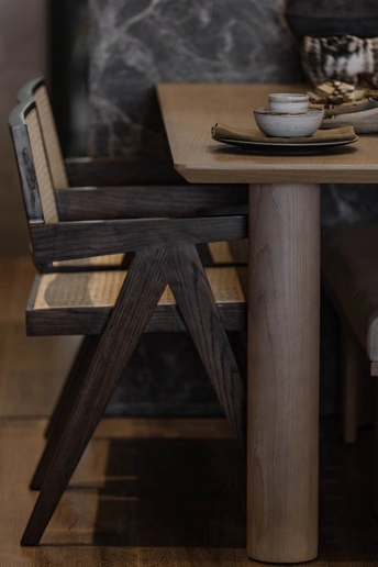 一张有椅子的木桌和一张上面有盘子和碗的长凳