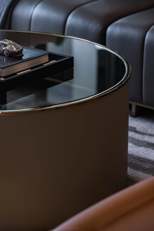 坐在黑色沙发前的圆形咖啡桌