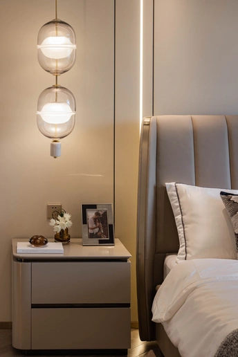 一间卧室 有一张带白色床头板和白色枕头的床 还有一个放着照片的床头柜