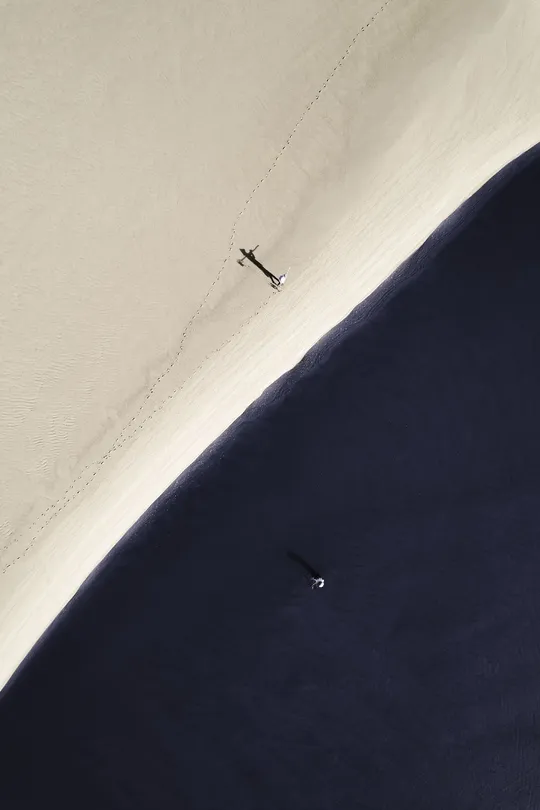 一片带有白色沙子的沙滩 水中有一艘小船的 aerial view