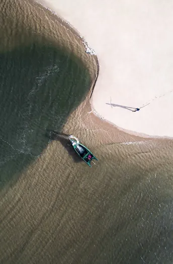 水上有一艘小船和人们在海洋中的海滩 aerial view