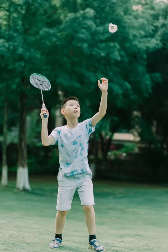 一个小男孩在公园的草地上玩耍