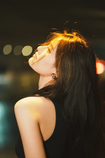 夜晚 一位穿着黑色连衣裙和眼镜的年轻女子