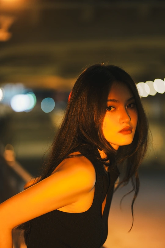 黑裙年轻女子站在夜晚街道上