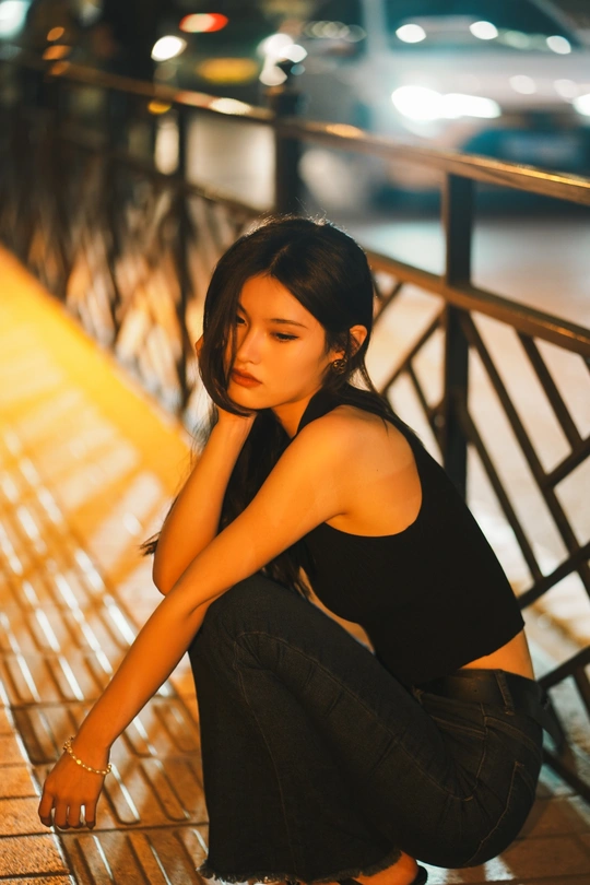 一个年轻女子独自坐在夜晚的长椅上