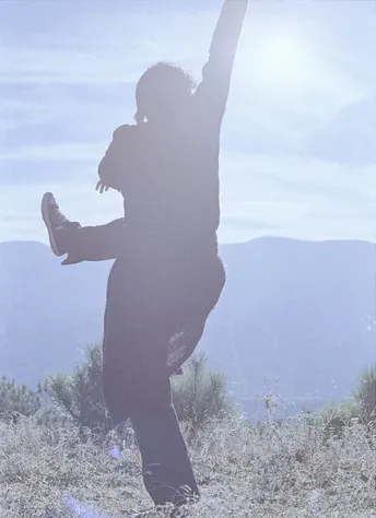 站在山顶上 双手举过头顶的女人