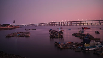 夕阳下 一座横跨在广阔水面上的长桥。