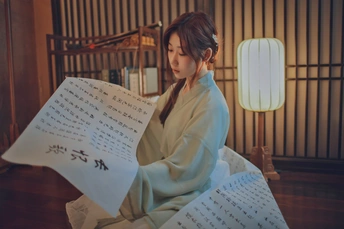 坐在地板上读报纸的年轻女子