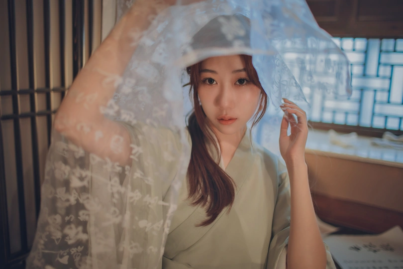 一个戴着面纱拿着手机的亚洲年轻女子