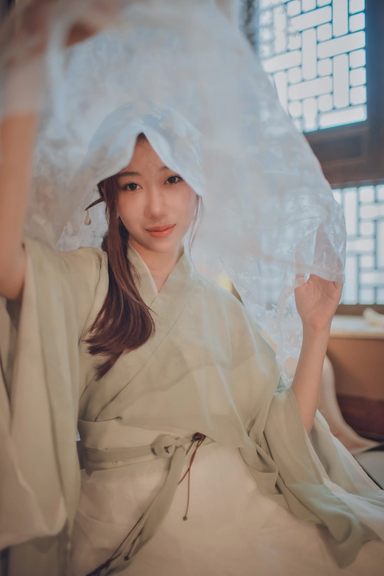 穿着白色长袍和面纱的年轻女子