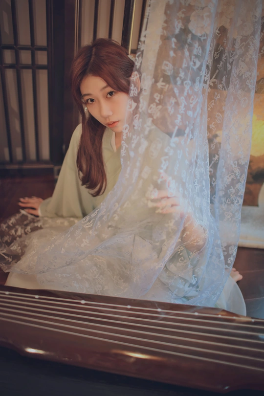 一个穿着白色衣服的年轻女人坐在床边