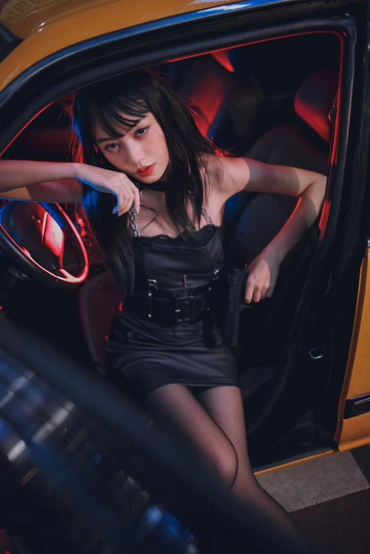 一个年轻女人坐在一辆黑色汽车里