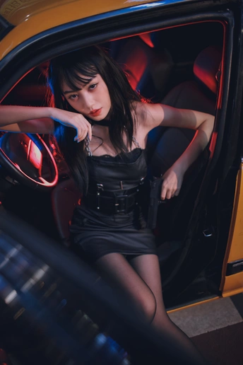 一个年轻女人坐在一辆黑色汽车里