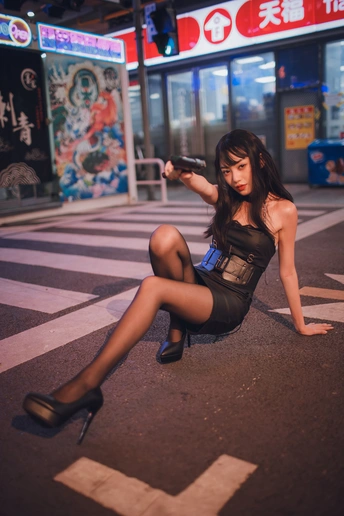 一个穿着黑高跟鞋的年轻女人晚上坐在街上