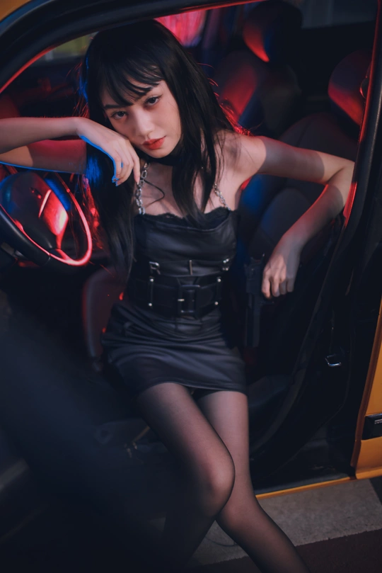 一个穿着红色衣服坐在车里的年轻女子