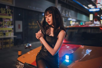 一个持枪的年轻女子站在一辆汽车前