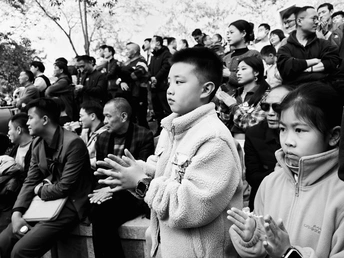 一个年轻男孩和一个小女孩站在人群前面
