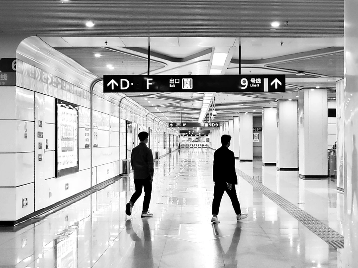 一张黑白照片 一对男人正在走路。