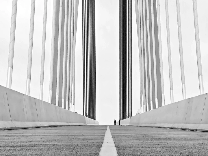 一个人带着伞走过一座高桥