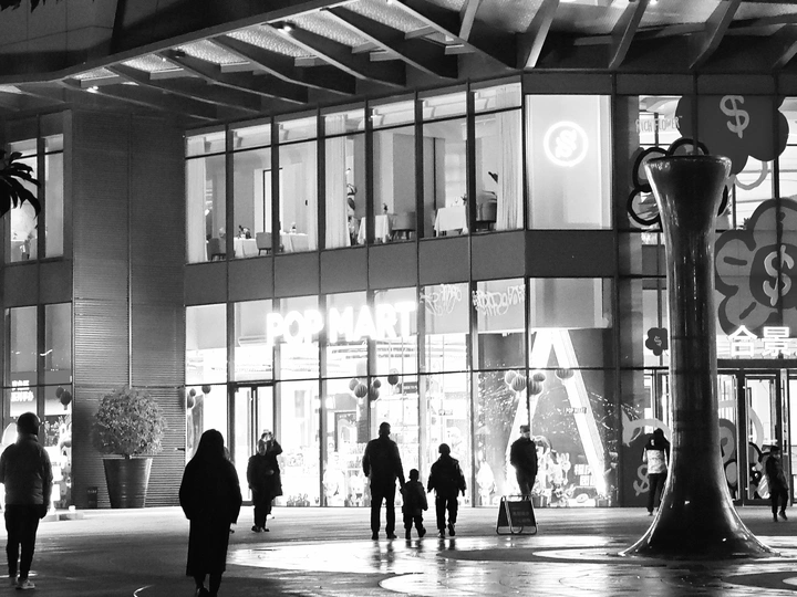 一张黑白照片 展示人们在建筑物的大厅里行走。