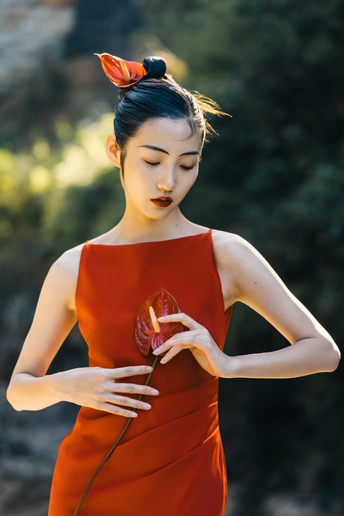 一位穿着红裙子的女人抱着花姿势