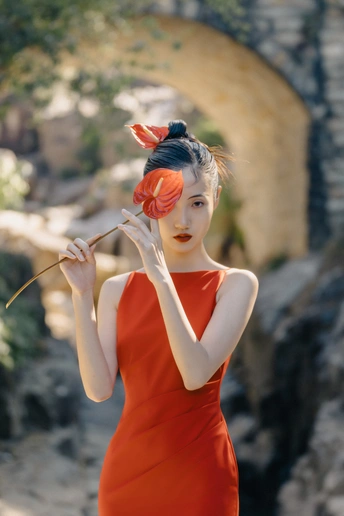 一位穿着橙色连衣裙 头戴红花的女性