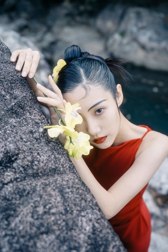 一位穿着红裙子的美丽年轻女子 头戴黄花