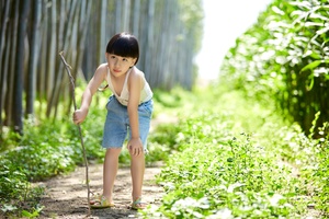 沿着竹林小径行走的一个小男孩和一个小女孩