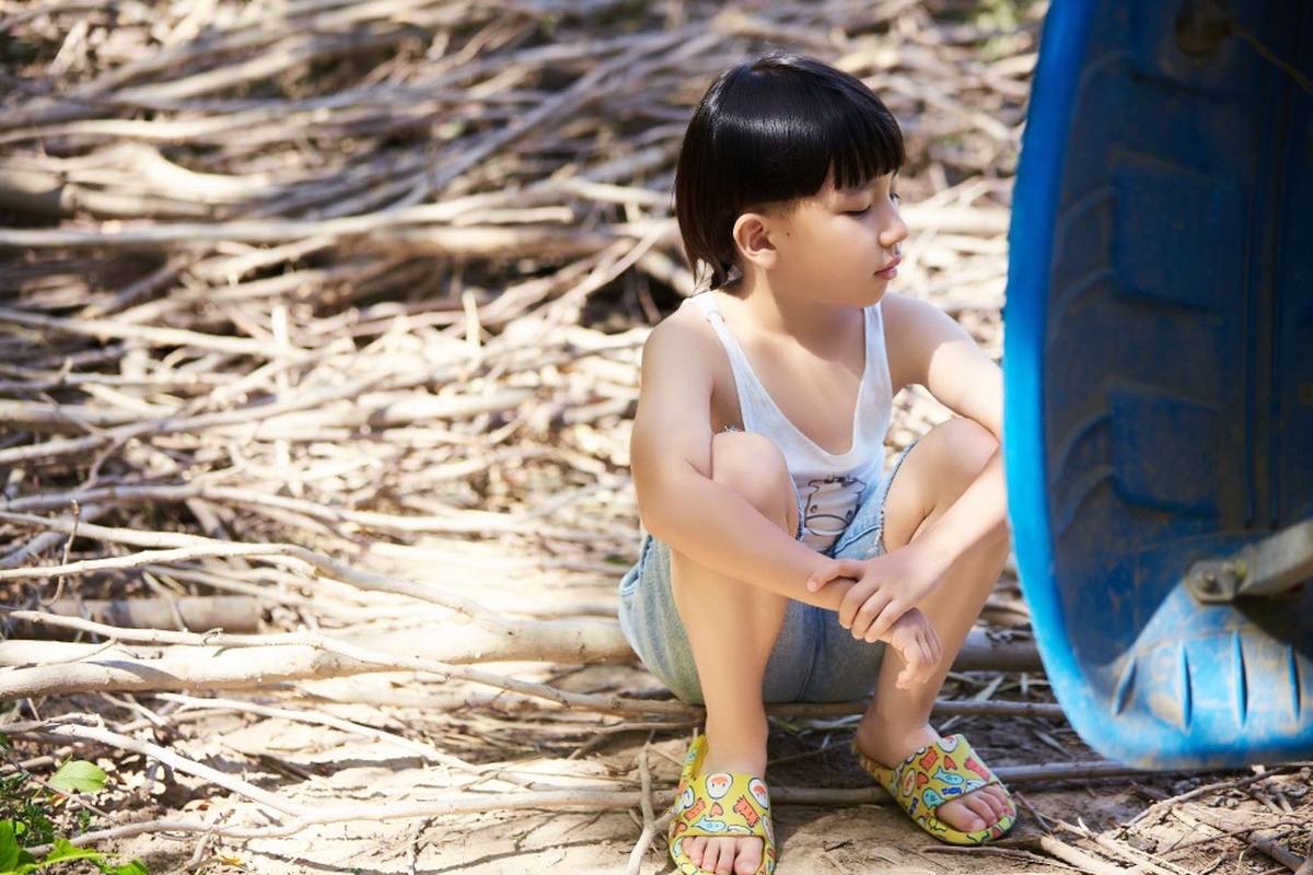 一个小女孩坐在轮胎上和一个小男孩一起玩。