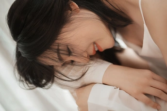 一个年轻女子躺在床上 她的头靠在头发上