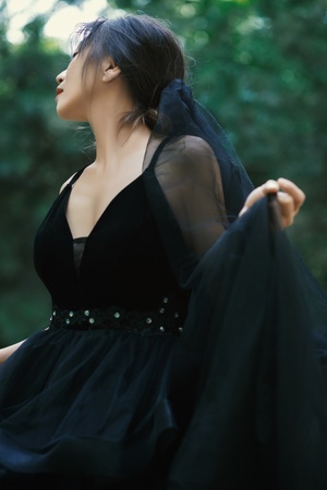 一位穿着黑色连衣裙的女子在森林中