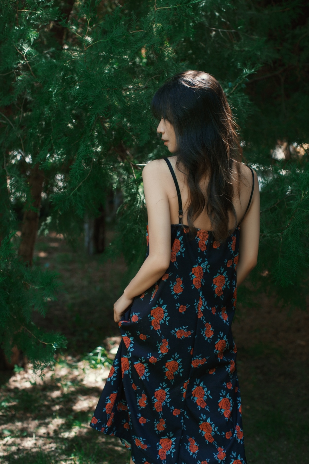 一位穿着花裙子的女人穿过森林