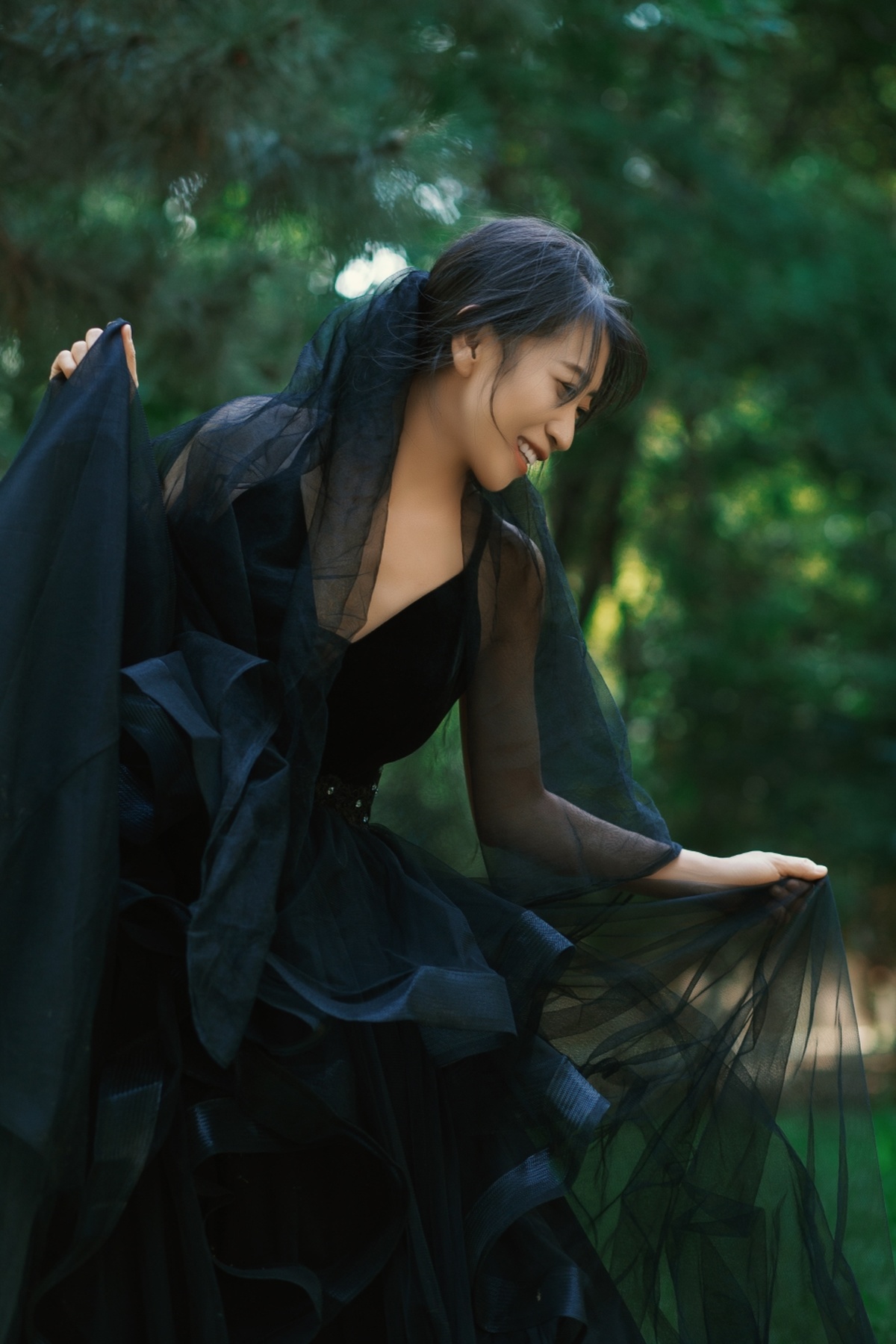 一个穿着黑色长袍的女孩在森林中
