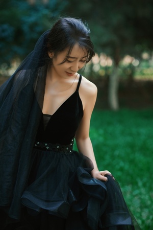 穿着黑色连衣裙的女孩在草地上