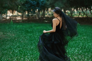 一个穿着黑色连衣裙的女人在田野中行走