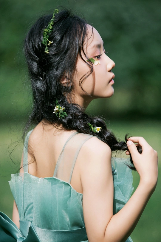 一位穿着绿色连衣裙 头戴花的女青年