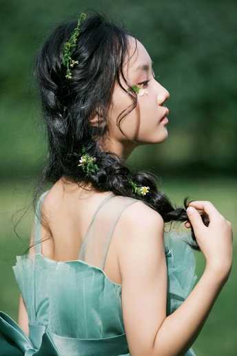 一位穿着绿色连衣裙 头戴花的女青年