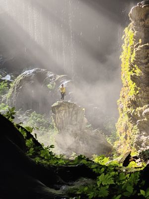 一个站在瀑布背景的洞穴中的男人