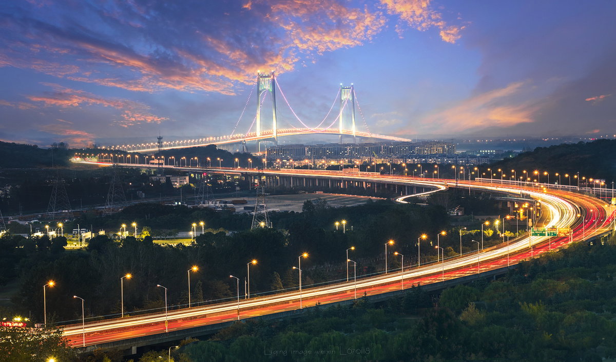 在黄昏或落日时 有灯光照在桥上的城市。