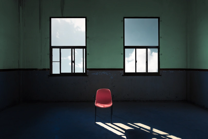 空房间中孤零零地坐着一把红椅子