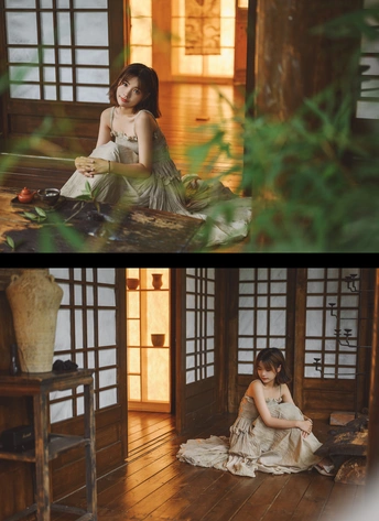 一位穿着连衣裙的年轻女孩坐在房子的地板上的一张照片