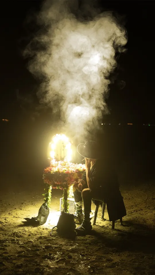 深夜里 人们坐在桌子旁 中间有蜡烛和花。