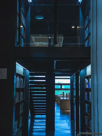 一个夜晚的建筑物里的黑暗走廊 楼梯上有蓝色的灯光。