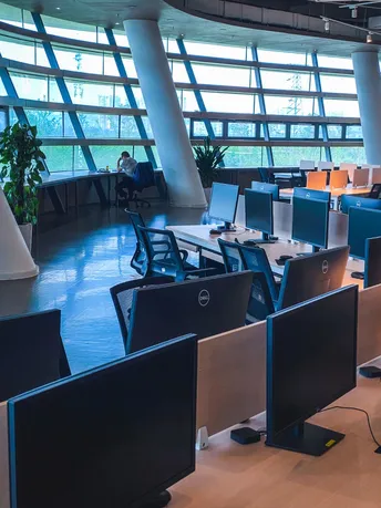 一个现代化的办公室 有大的窗户和一张带有桌子和椅子的图书馆。